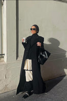 Black Kris Marán straight cut coat with signature buttons, featuring a sleek design and tailored fit.