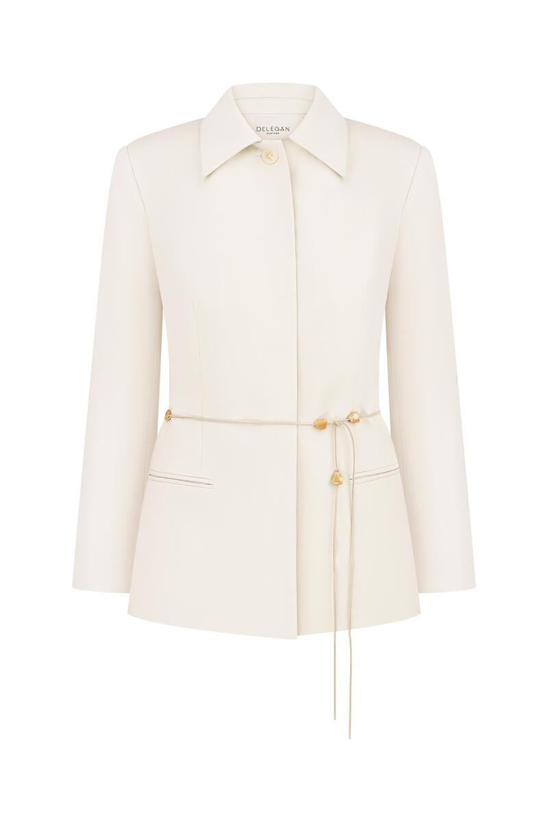 White and gold belted jacket by Delegan displayed on a ghost mannequin, front view showing stylish design and belt details.