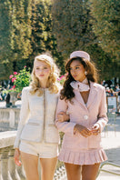 Pink GIA mini skirt by Nana Jacqueline featuring pleated design, shown in a stylish campaign image.