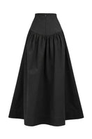 Black Ginevra maxi skirt by ANA + MARIA, flowing fabric with a stylish silhouette, displayed in a ghost photo style.