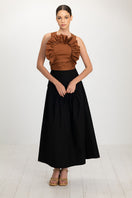 Black Ginevra maxi skirt by ANA + MARIA displayed on a model, featuring flowing fabric and a high waist design.