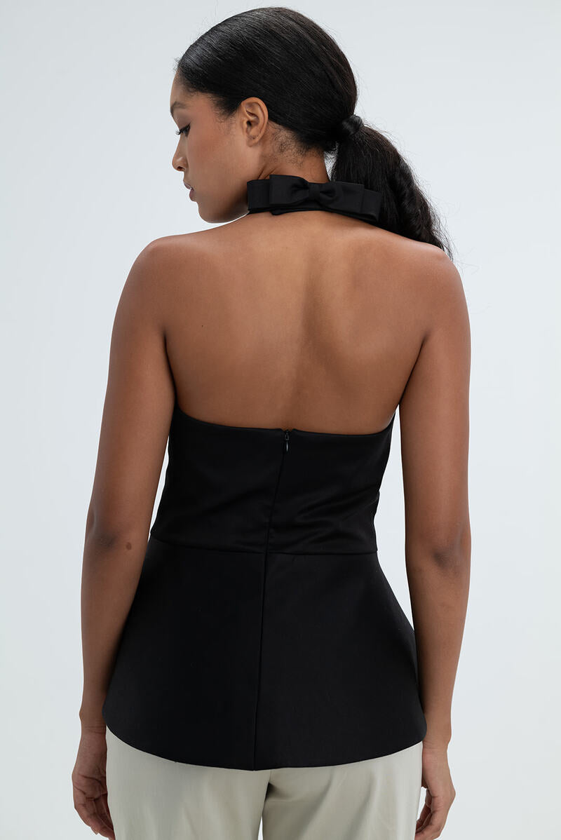 Black Giselle top by ANA + MARIA, shown on model, featuring fitted design with long sleeves and neckline detail.