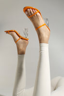 House of Atana Fiorellini orange patent glass mule sandals with clear glass heels and vibrant orange color.
