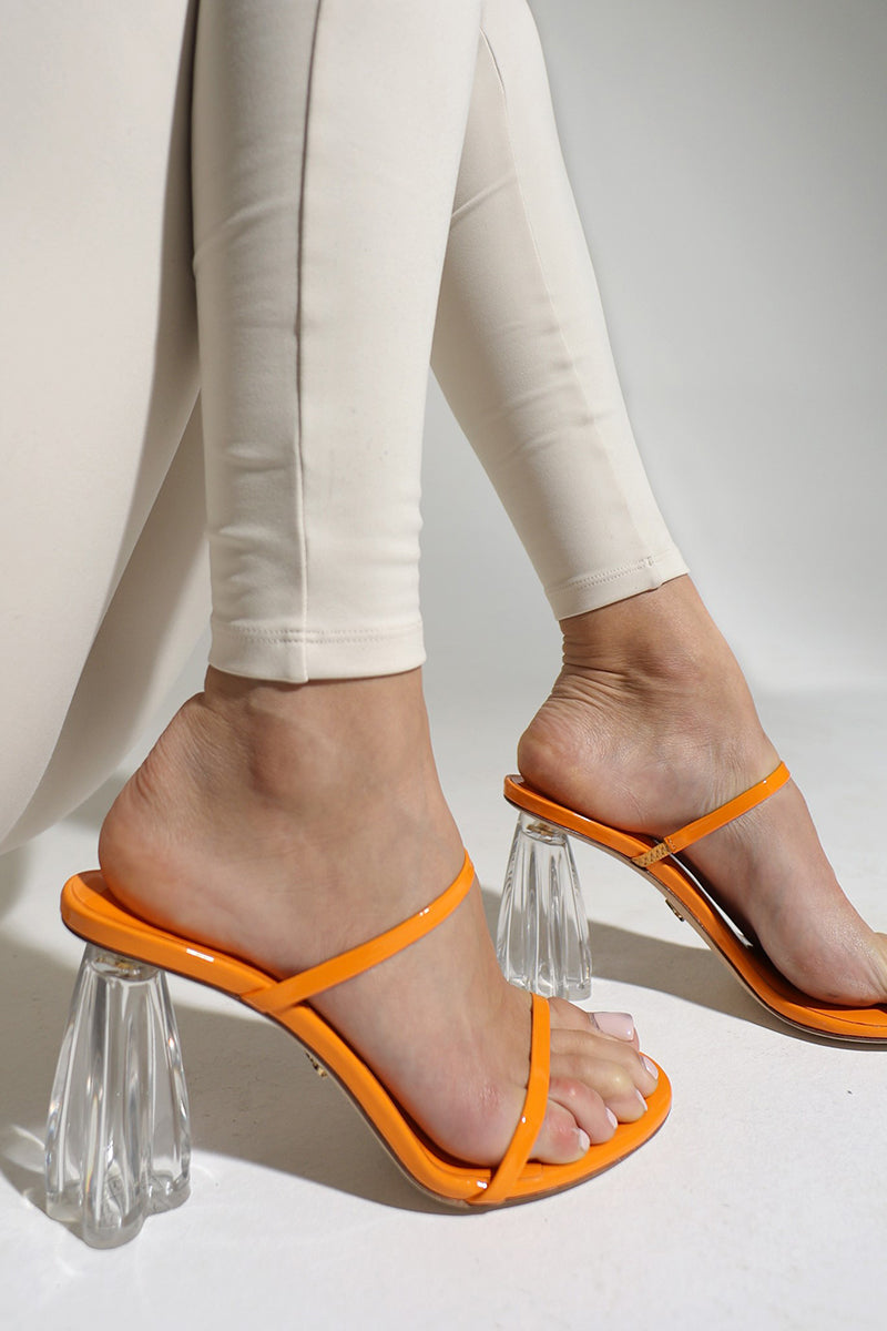 Orange patent glass mule sandals by House of Atana featuring clear glass heels and stylish design.