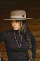 Gold and beige canotier hat by LE SH KA, stylish wide-brim hat with elegant design and natural straw texture.