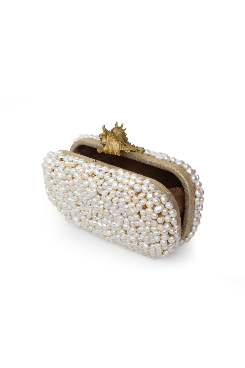 White clutch bag from Sarah's Bag Golden Murex Loulou collection, featuring a sleek design and gold accents.