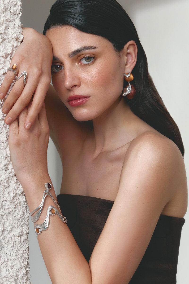 Silver and tan Gravity bracelet by Jude Benhalim featuring sleek metallic and leather elements, displayed on a neutral background.