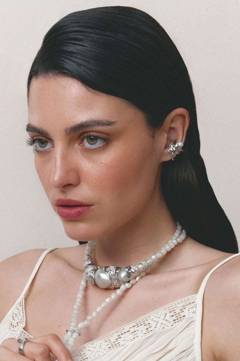 Silver Gravity Ear Cuff earrings by Jude Benhalim, featuring a sleek, modern design and a smooth, curved shape on a plain background.