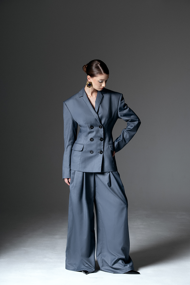 Liya double-breasted charcoal blazer with notch lapels and tailored fit, shown on a hanger against a neutral background.