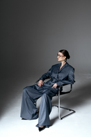 Liya double-breasted charcoal blazer with notch lapels, tailored fit, and front buttons on a gray fabric background.