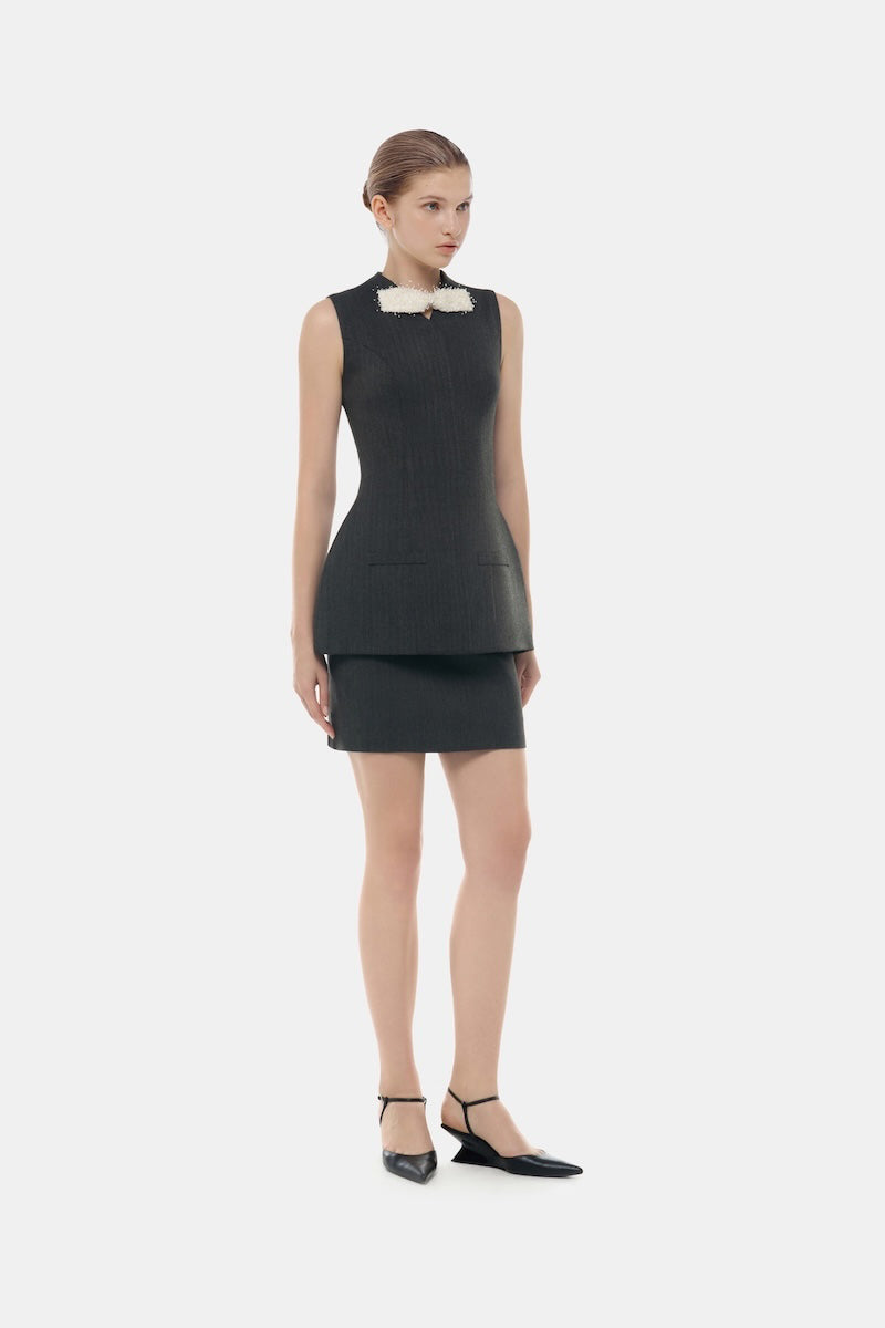 Gray sleeveless blazer with bow detail from Montsand, styled with a grey tweed skirt, perfect for chic, sophisticated tops.