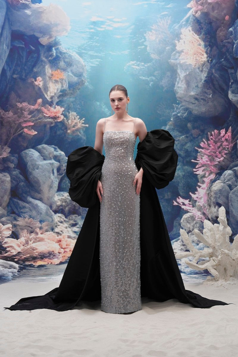 Elegant Moirae sequin gown and Marisol taffeta cape by 21Six, displayed on a mannequin with intricate detailing and luxurious fabric.