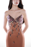 Elegant blush nude gown by HACCHIC COUTURE featuring embellishments and a fitted column silhouette.