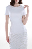 Elegant ivory Camellia Pearl Column Gown by HACCHIC COUTURE, featuring intricate pearl details and a sleek, fitted silhouette.