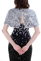 Black and silver Luna Crystal Cape Gown by HACCHIC COUTURE featuring intricate crystal embellishments and flowing fabric.