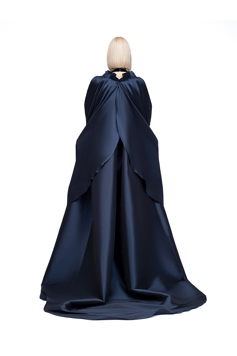 Navy Lotus Cape jacket by MOON / HAKAN YILDIRIM, featuring flowing fabric and elegant design, shown on a model.