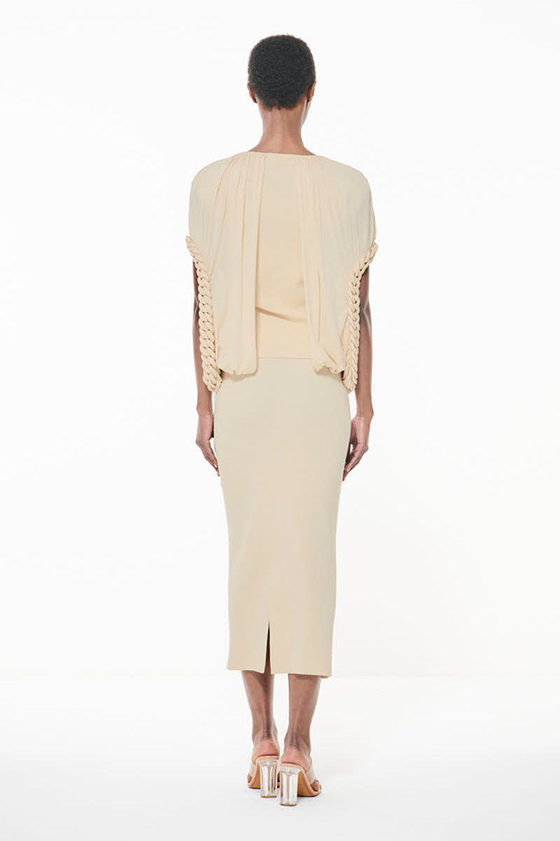 Off-white Leem knit top with chain detail, showcasing a close-up of the textured fabric and chain accents in natural lighting.