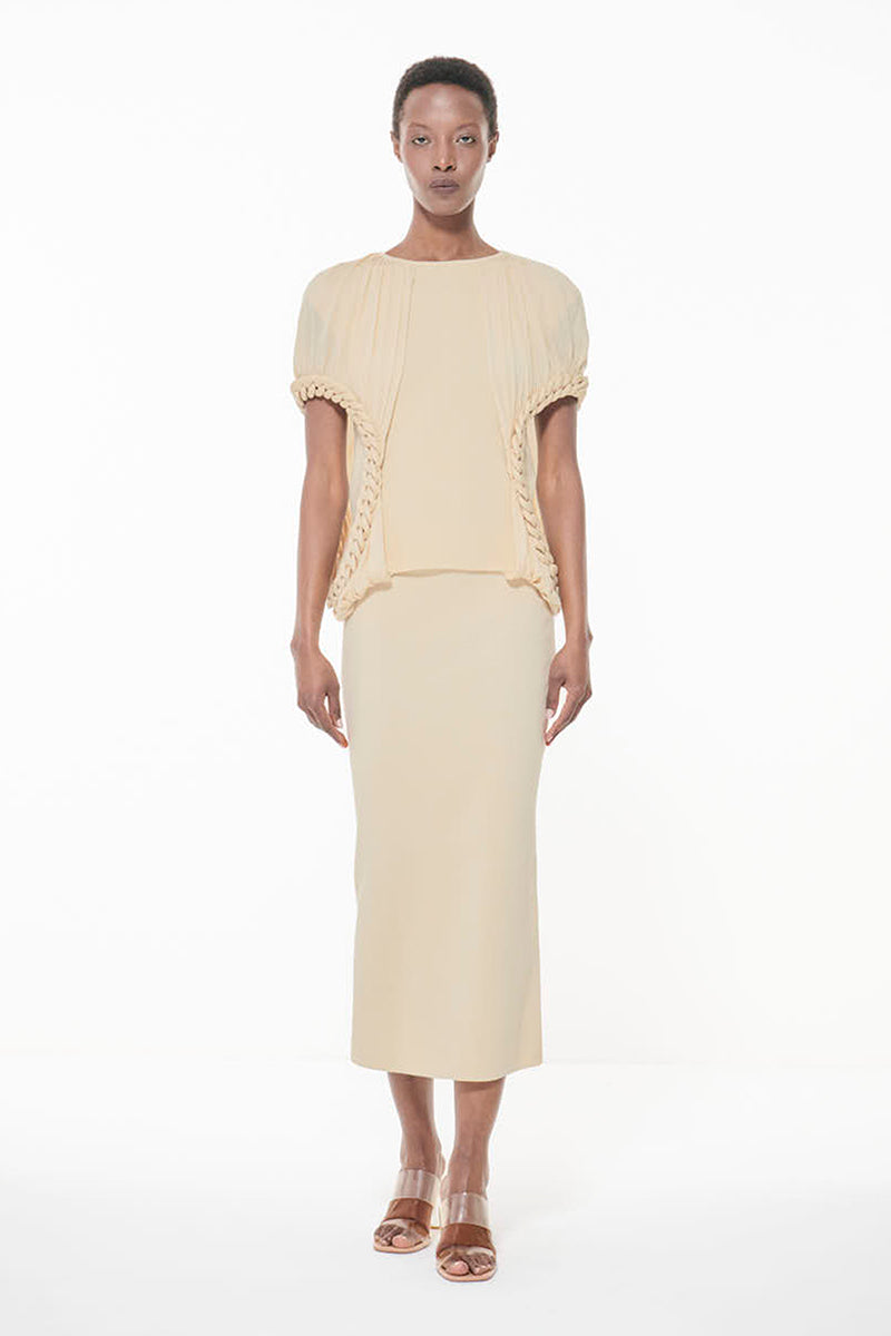 Off-white knit pencil maxi skirt by Leem, showcasing a fitted design with ribbed texture and high waist for a stylish look.
