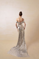 Elegant silver couture gown by HACCHIC COUTURE featuring intricate detailing and a flowing silhouette.