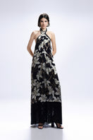 Black Valenciani halter-neck maxi dress with floral print, flowing fabric, and elegant design perfect for summer or special occasions.