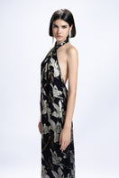 Black Valenciani halter-neck floral printed maxi dress showcased on a model, featuring flowing fabric and elegant design.