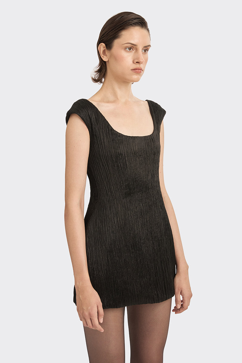 Black hand-pleated mini dress from Stolen Stores, showing the textured fabric and stylish fit on a model.