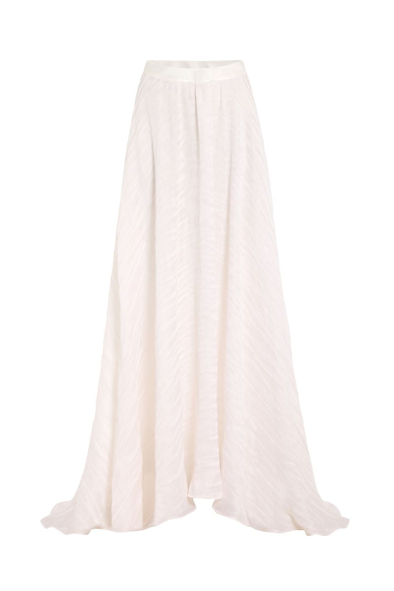 White maxi skirt from IKINITA's Innocent Skirt collection, flowing fabric and elegant design perfect for casual or dressy wear.