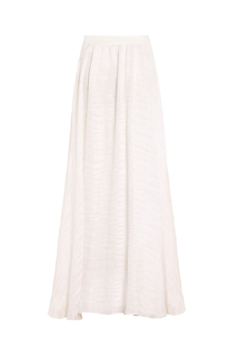 White maxi skirt by IKINITA, featuring a flowing design and lightweight fabric, perfect for casual or elegant outfits.