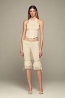 IKINITA Wave Top in Sand, stylish sleeveless blouse with wave details, lightweight fabric, perfect for casual or beachwear.