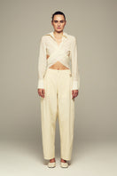 IKINITA Ulysse yellow pants displayed on a hanger, showcasing their butter yellow color and tailored fit.