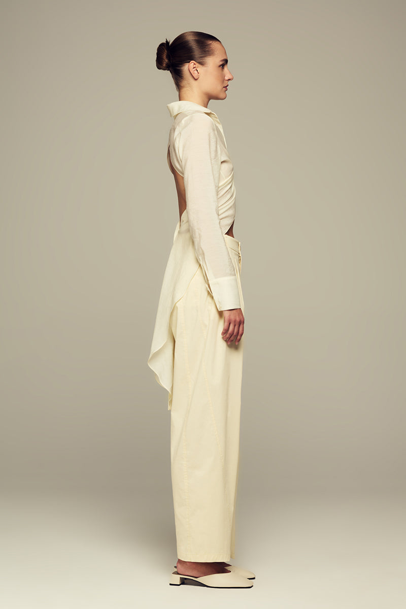 IKINITA ULYSSE yellow pants in butter shade, casual fit with smooth fabric, displayed on a hanger against a neutral background.