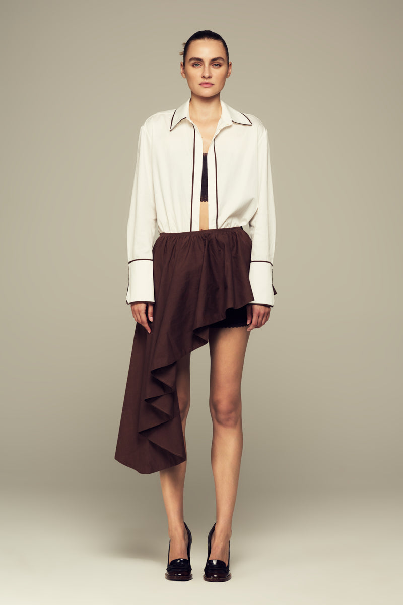 Brown modular mini skirt by IKINITA, featuring layered design and adjustable fit, shown on a neutral background.
