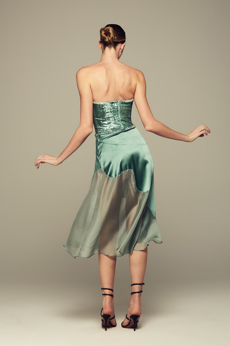Emerald green Nausica midi skirt by IKINITA, featuring flowing fabric and stylish design, displayed on a white background.