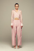 Pink Ulysse pants by IKINITA, featuring a relaxed fit with side pockets and a stylish waistband.
