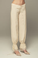 Cream SCYLLA Pants by IKINITA featuring a relaxed fit and stylish design, displayed on a neutral background.
