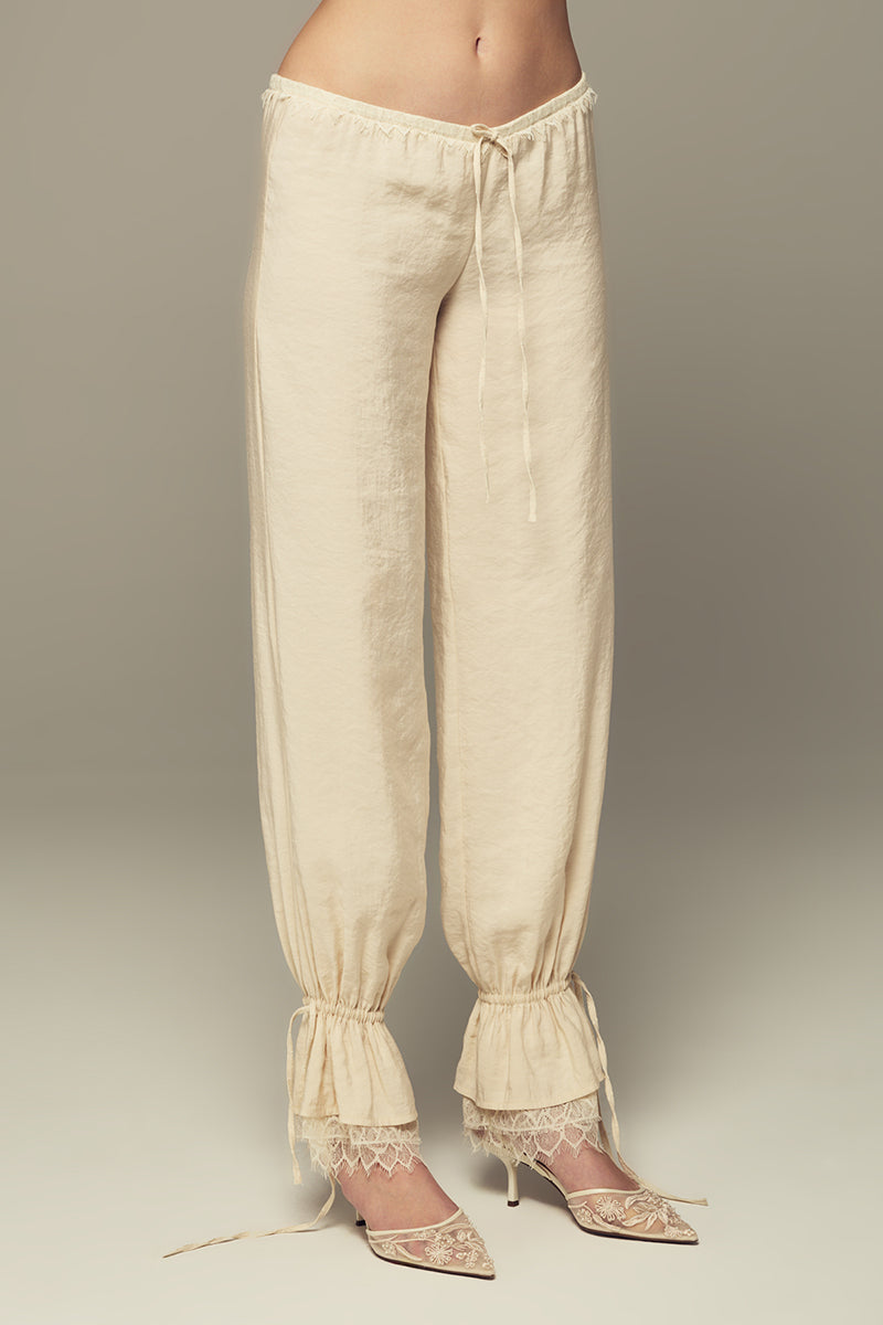 Cream SCYLLA Pants by IKINITA featuring a relaxed fit and stylish design, displayed on a neutral background.