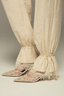 Cream SCYLLA pants by IKINITA, featuring a relaxed fit with a smooth fabric finish, displayed on a plain background.