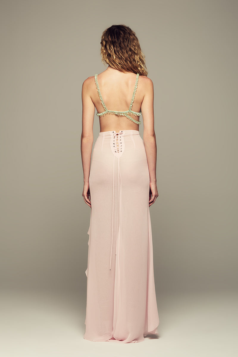 Pink IKINITA Lotus Eater maxi skirt with flowing fabric and waistband, shown on a model.