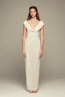 Elegant white Scylla gown by IKINITA displayed on a mannequin, featuring flowing fabric and stylish design details.