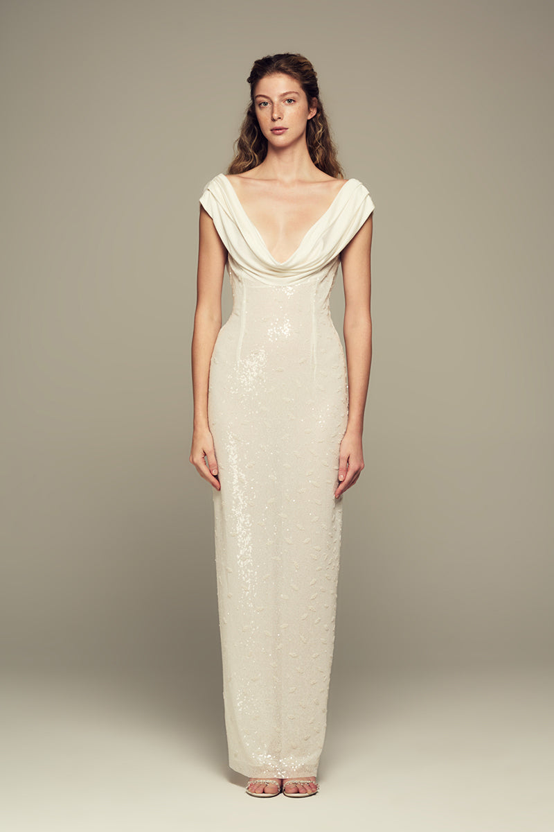 Elegant white Scylla gown by IKINITA displayed on a mannequin, featuring flowing fabric and stylish design details.