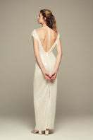 Elegant white Scylla gown by IKINITA featuring flowing fabric and intricate detailing, perfect for formal occasions.