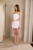 Pink polka dot mini skirt from IKINITA featuring a playful white background and a stylish, flirty design.