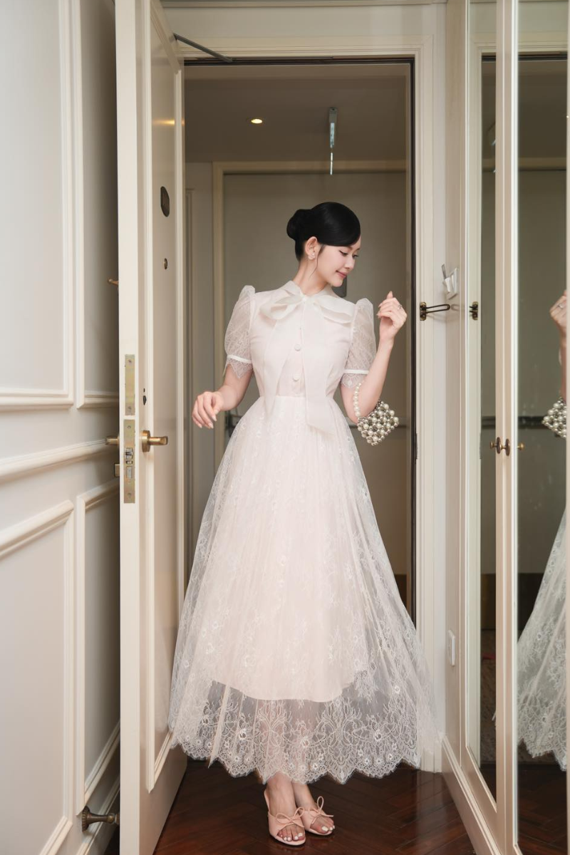 White Plan ILLEN midi dress featuring a sleek, stylish design with a fitted waist and flowing skirt on a model.