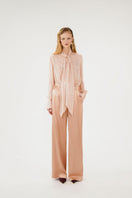 Beige IMAN silk pants by Mastani, featuring a smooth, flowing fabric and tailored fit, displayed on a neutral background.