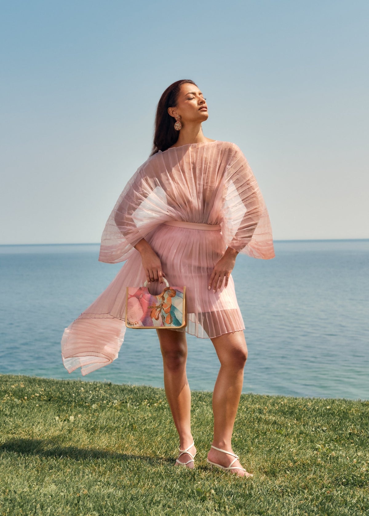 Powder pink Andrea Iyamah IME mini skirt displayed on a hanger, showcasing its stylish short length and vibrant color.