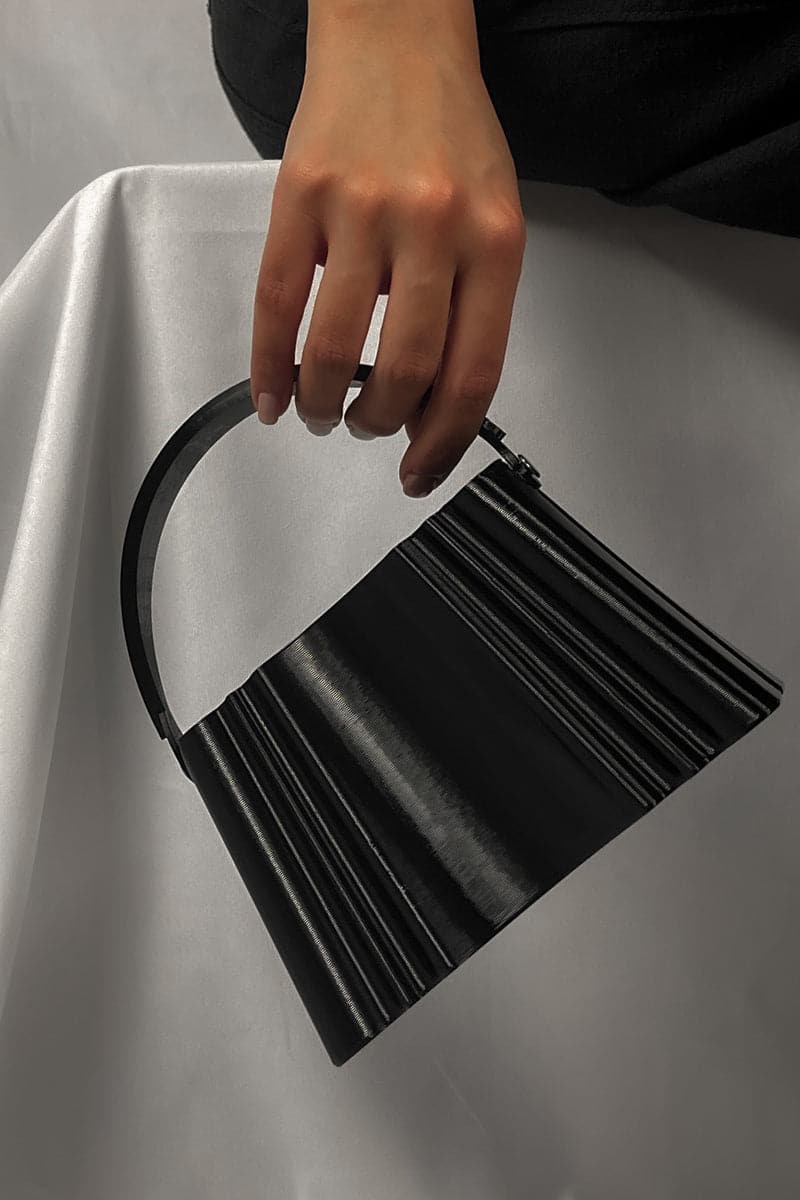 Black silk clutch bag by Touchless, sleek and elegant with a smooth fabric exterior and compact design for evening use.