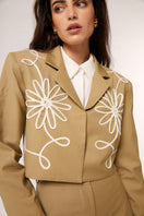 Señorita beige Lara pants, stylish with a tailored fit, shown hanging on a hanger against a neutral background.