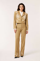 Beige Señorita Lara pants displayed on a model, showing relaxed fit and stylish design perfect for casual or chic outfits.
