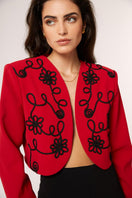 Red Señorita Rosalia jacket featuring a stylish design and tailored fit, shown hanging on a white background.