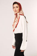 Red Señorita Luisa scarf draped over a neutral background, showcasing soft fabric and elegant design.